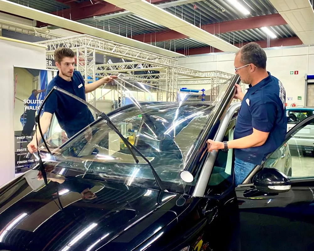 2 Trainers demonstreren plakken van raamfolie op bolle ruit tijdens Appcademy Automotive Windowfilm opeiding