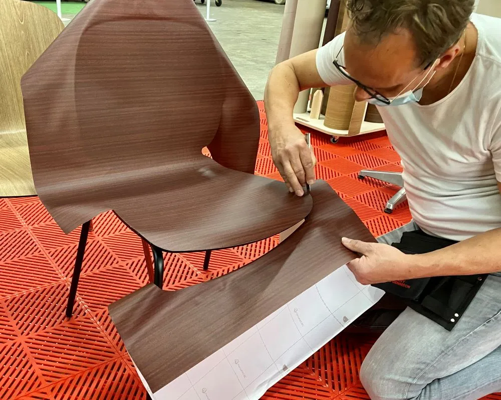 Cursist doet praktijkoefening stoel wrappen tijdens de Appcademy cursus interieurfolie en keukens wrappen