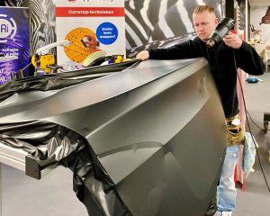 Trainer demonstreert wrappen van achterklep uit 1 deel carwrapfolie tijdens Appcademy carwrap advanced cursus