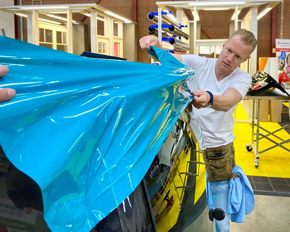 Trainer demonstreert wrap van een achterspoiler tijdens Appcademy carwrap opleiding