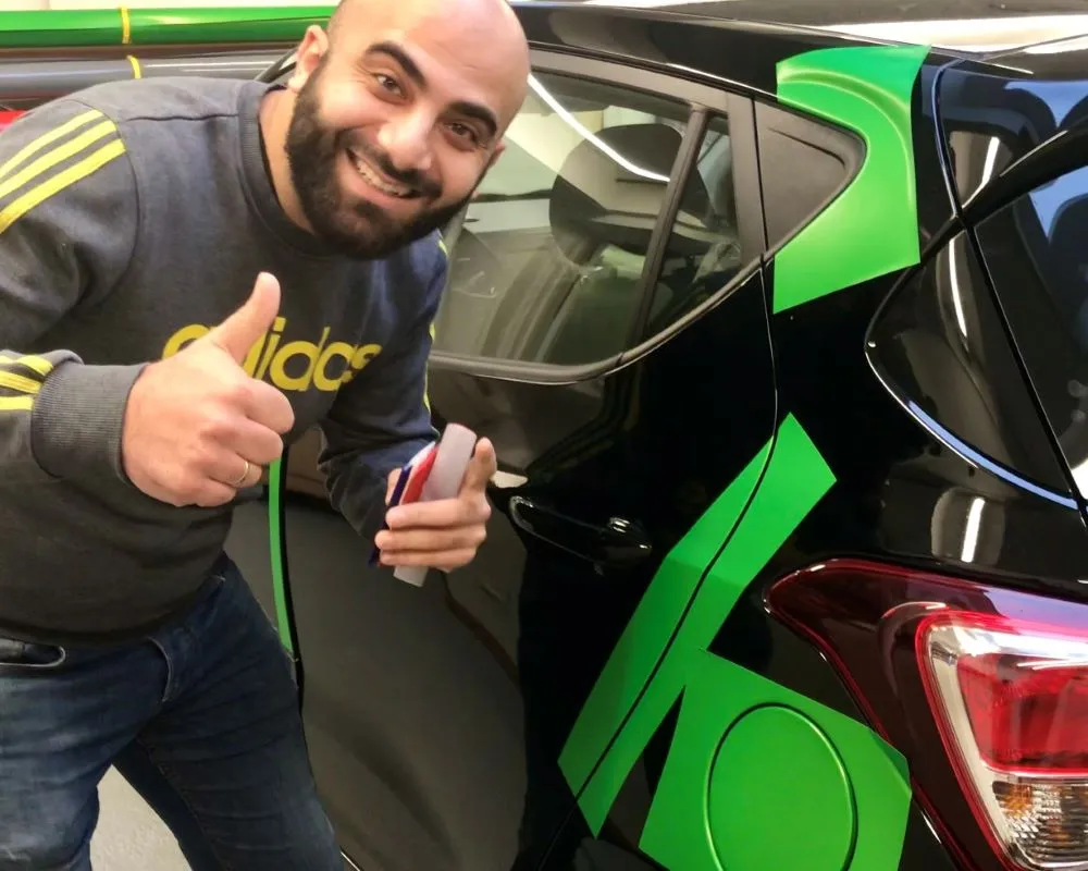 Cursist is blij met resultaten van praktijkoefeningen Appcademy carwrap training opleiding