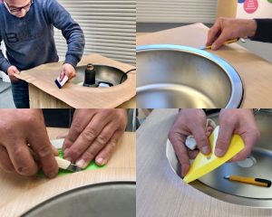 Cursisten beplakken aanrechtblad rond spoelbak als praktijkoefening tijdens de Appcademy training interieurfolie appliceren en keukens wrappen