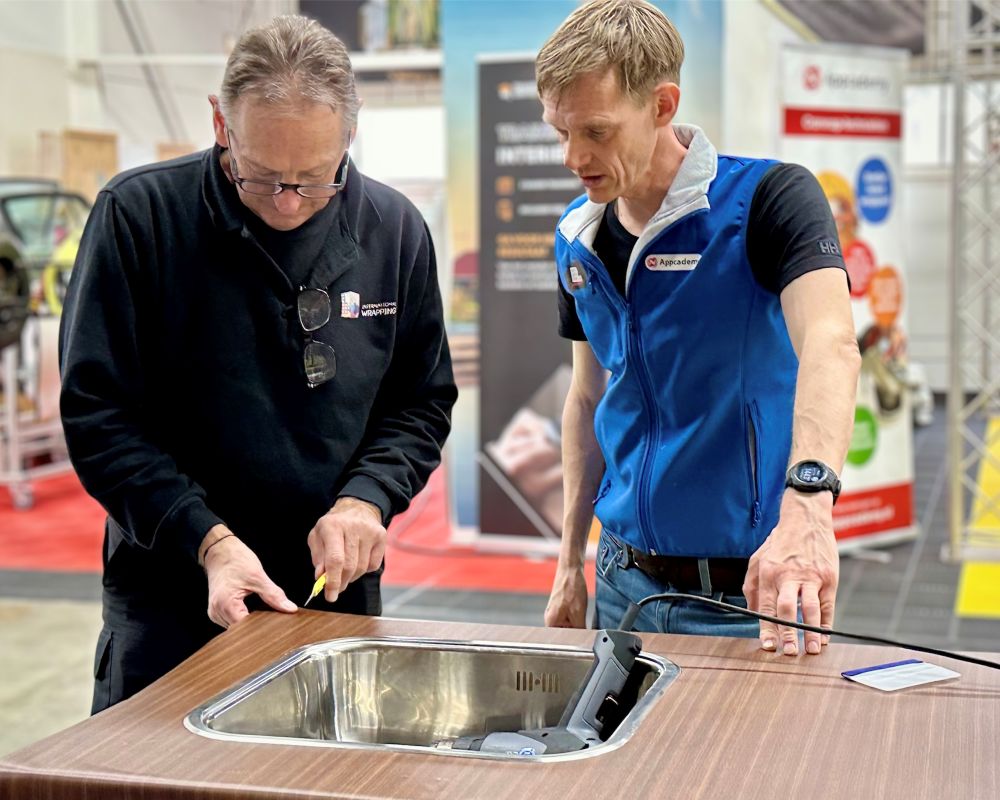 trainer geeft uitleg aan cursist tijdens cursus interieuerfolie: keukens Wrappen van A-Z