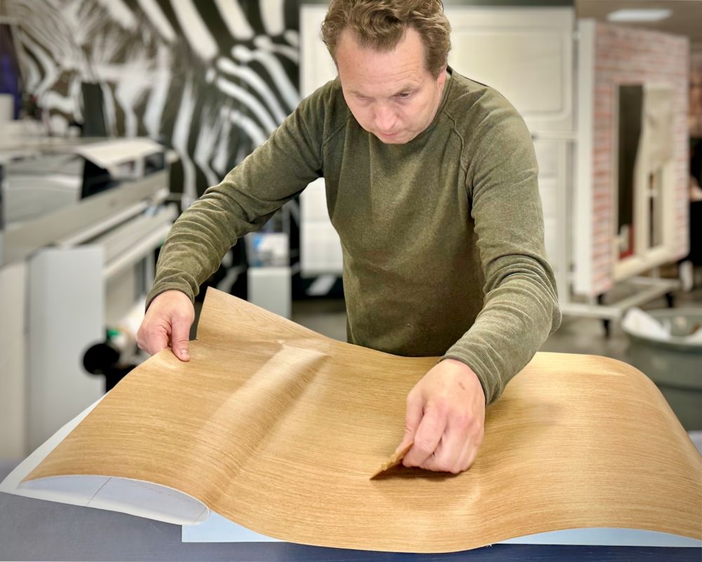 cursist brengt Interieurfolie aan op aanrechtblad tijdens Appcademy cursus Keukens Wrappen van A-Z